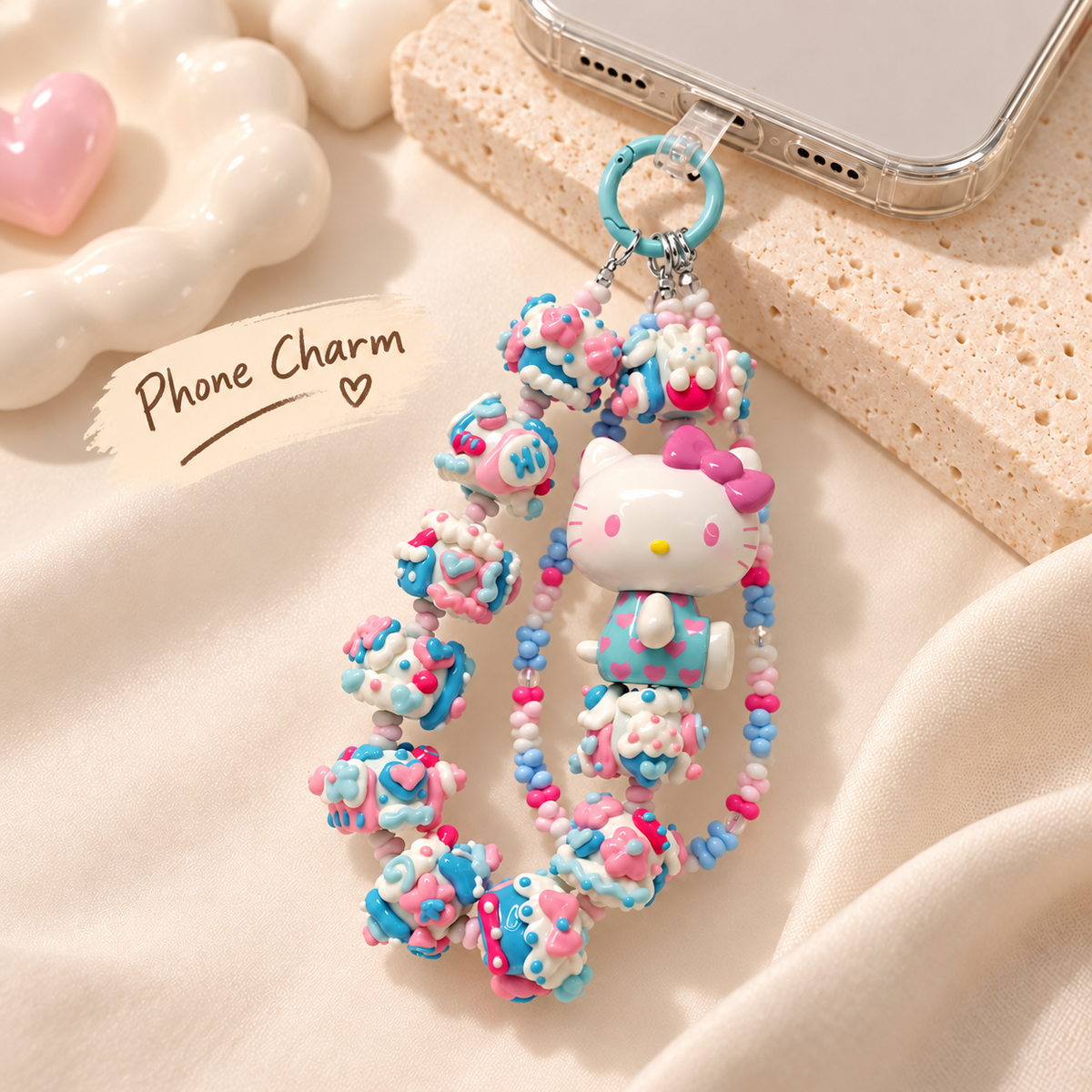 Blue pink Hello Kitty phone charm connected to the bottom of a phone case