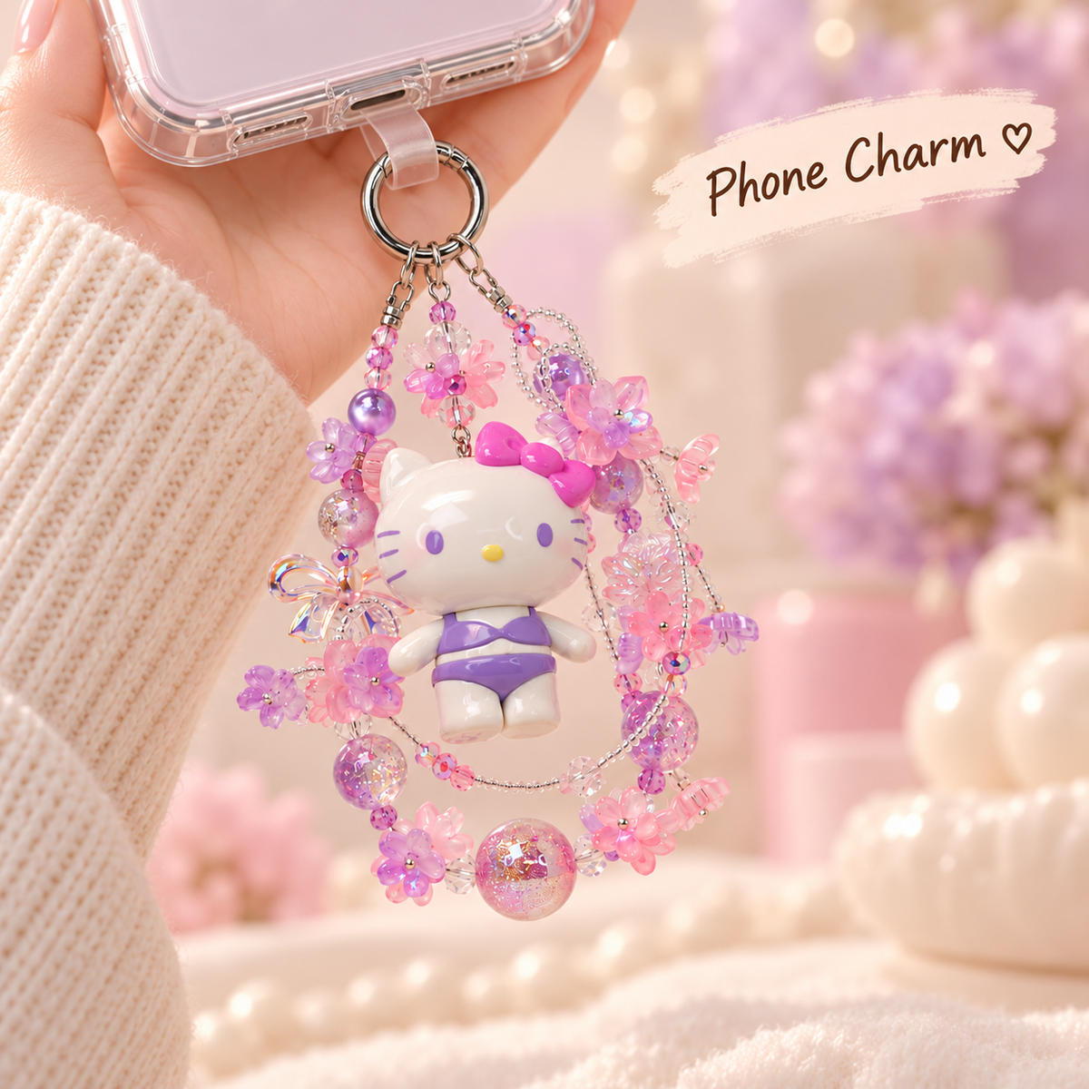 Hello Kitty glitter bead charm connected at the bottom edge of a clear phone case